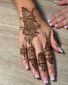 two hands with henna tattoos on them