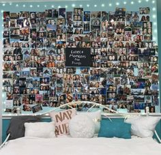 a bed with many pictures on the wall behind it