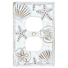 a decorative light switch cover with shells and flowers on the front, in white metal