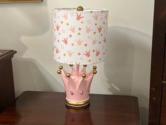 a pink lamp sitting on top of a wooden table