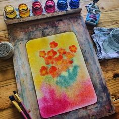 a wooden table topped with lots of different colored paints