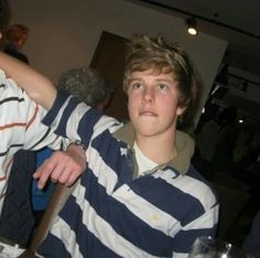 two young men standing next to each other at a table