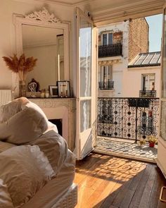 an open door leading to a balcony with a bed and mirror on it's side