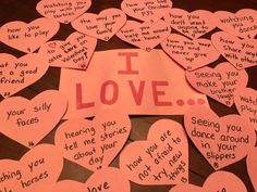 a bunch of pink paper hearts with words written on them that say i love you