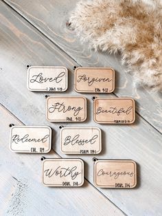 wooden name tags with names on them sitting on a wood floor next to a teddy bear