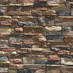 a brick wall made out of various colored rocks