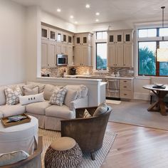 a living room filled with furniture next to a kitchen and breakfast nook in a home