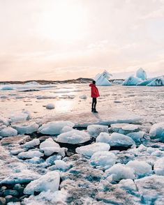 a person standing on an ice floet with mountains in the background