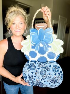 a woman holding up a blue and white purse