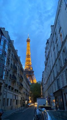 the eiffel tower in paris is lit up at night, as seen from an empty street