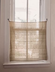 a window with a curtain hanging from it's side