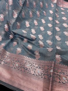 Gorgeous Semi Banarasi Silk Saree in Light Grey Color with Copper and Sliver Zari Work with Floral Designs. Please note - The border and Pallu might look like gold in the pictures however it is Copper. Item : SareeBase Fabric : Semi Banarasi SilkColor : Light Grey Color and Copper Blouse piece : Comes with un-stitched Blouse piece.Blouse material : Semi Banarasi SilkFall & Edging(Yes/No) : Yes Disclaimer -:- Color variation is possible due to various reasons like phone or desktop setting, resolu Festive Silver Blouse Piece For Festivals, Festive Silver Blouse Piece, Silver Banarasi Silk Traditional Wear With Self Design, Silver Art Silk Saree For Eid, Silver Chanderi Traditional Wear For Eid, Silver Bollywood Dupatta For Transitional Season, Bollywood Style Silver Dupatta For Transitional Season, Silver Zari Weaving Unstitched Saree, Silver Unstitched Saree With Zari Weaving