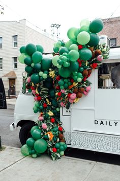 balloons are attached to the back of a food truck