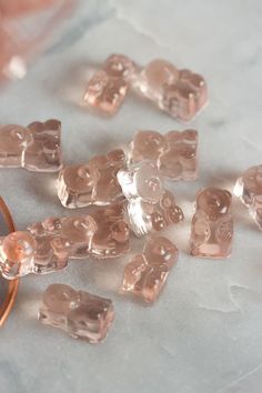 some clear cubes are sitting on a table next to a glass bowl and spoon