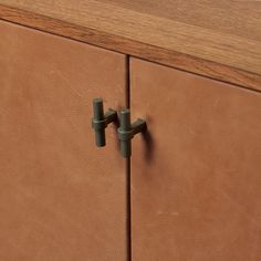 a close up of a brown cabinet with two handles