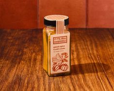 a glass jar filled with honey sitting on top of a wooden table