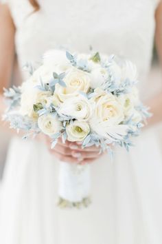 a bridal holding a bouquet of white flowers