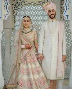 two people standing next to each other in wedding outfits