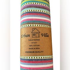 a roll of multicolored striped fabric with a house label on the front and side