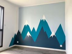 an empty room with mountains painted on the wall