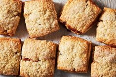 several square pieces of cake sitting on top of a white tablecloth next to each other