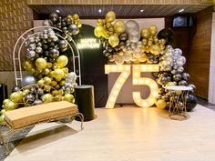 a room decorated with balloons and lights for 75th birthday