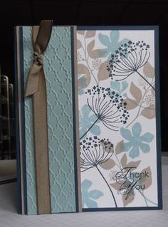 a thank you card with blue flowers and brown ribbon on the bottom, in front of a window