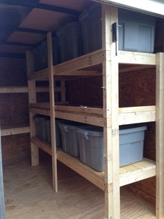 the inside of a storage shed with bins and shelves