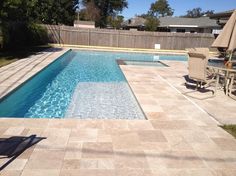 an empty swimming pool surrounded by patio furniture