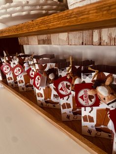 several small boxes are lined up on a shelf in a room with wood paneling