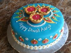 a blue cake with gold decorations and happy diwali aaar written on it