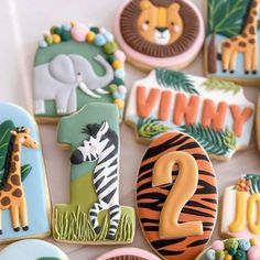 decorated cookies with animals and numbers are displayed on a table in front of the camera