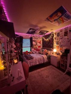 a bedroom decorated in pink and purple lights with pictures on the wall, bed spread across the room