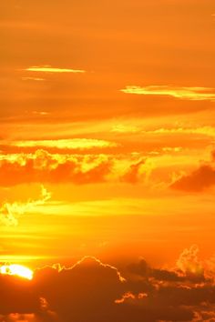 an airplane is flying in the sky at sunset with clouds and sun flares behind it