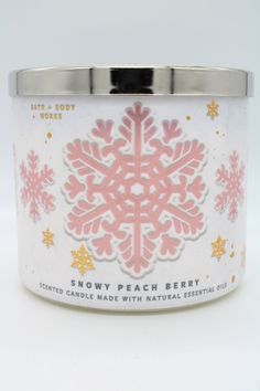 a white and pink candle with snowflake designs on it's lid is shown