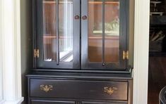 a black china cabinet with glass doors and drawers