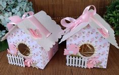 two little bird houses with pink bows on them