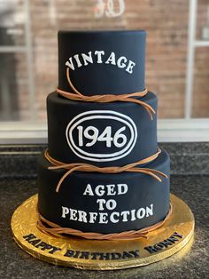 a black and gold birthday cake with an aged to perfection sign on it's side