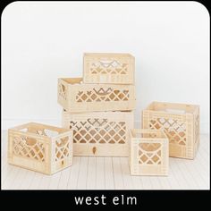 four wooden crates stacked on top of each other in front of a white wall and floor