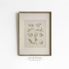 an art print is mounted on the wall above a framed artwork piece that has animals in it