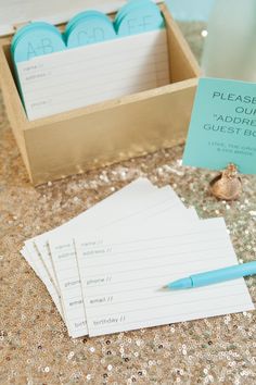 there is a notepad, pen and some paper in a box on the table