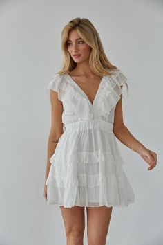 Embrace your femininity in the Xena Flutter Sleeve Babydoll Mini Dress! This mini dress features flutter sleeves, a V-neckline, tiered ruffle skirt, and a triple clasp bust detail. Available in white and blue. Pair with some heels to complete the look! Details 75% Rayon, 25% Nylon Lining: 100% Polyester Elastic waistband Elastic band sleeves Hand wash cold Sorority Rush, American Threads, Babydoll Mini Dress, Tiered Ruffle Skirt, Ruffle Romper, Flutter Sleeve Dress, Mini Dress Shop, Ruffle Skirt, Flutter Sleeves