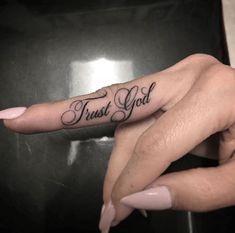 two hands with tattoos that say trust god