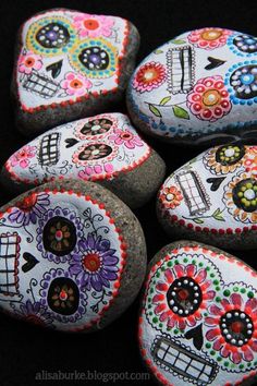 some rocks that have been painted to look like skulls and flowers on them, with the caption mom's got ink's post