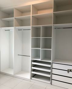 an empty walk in closet with white shelving and drawers on each side, all closed