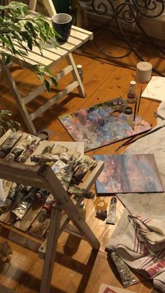 an artist's studio with various paints, brushes and canvass on the floor