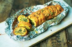 a piece of food that is on top of tin foil and sitting on a cutting board