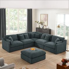 a living room filled with furniture and a large blue sectional couch sitting on top of a hard wood floor