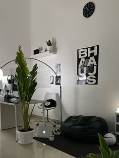 a living room filled with furniture and a clock on the wall next to a potted plant