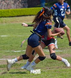 the girls are playing football on the field with each other and one is running after the ball